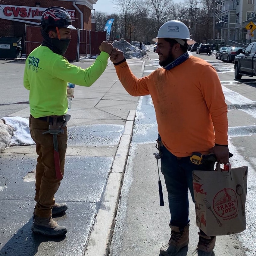 Two workers high fiving at concrete jobsite