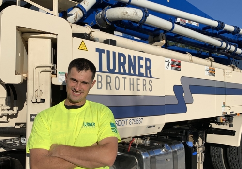 Turner Brothers employee in front of concrete pump truck